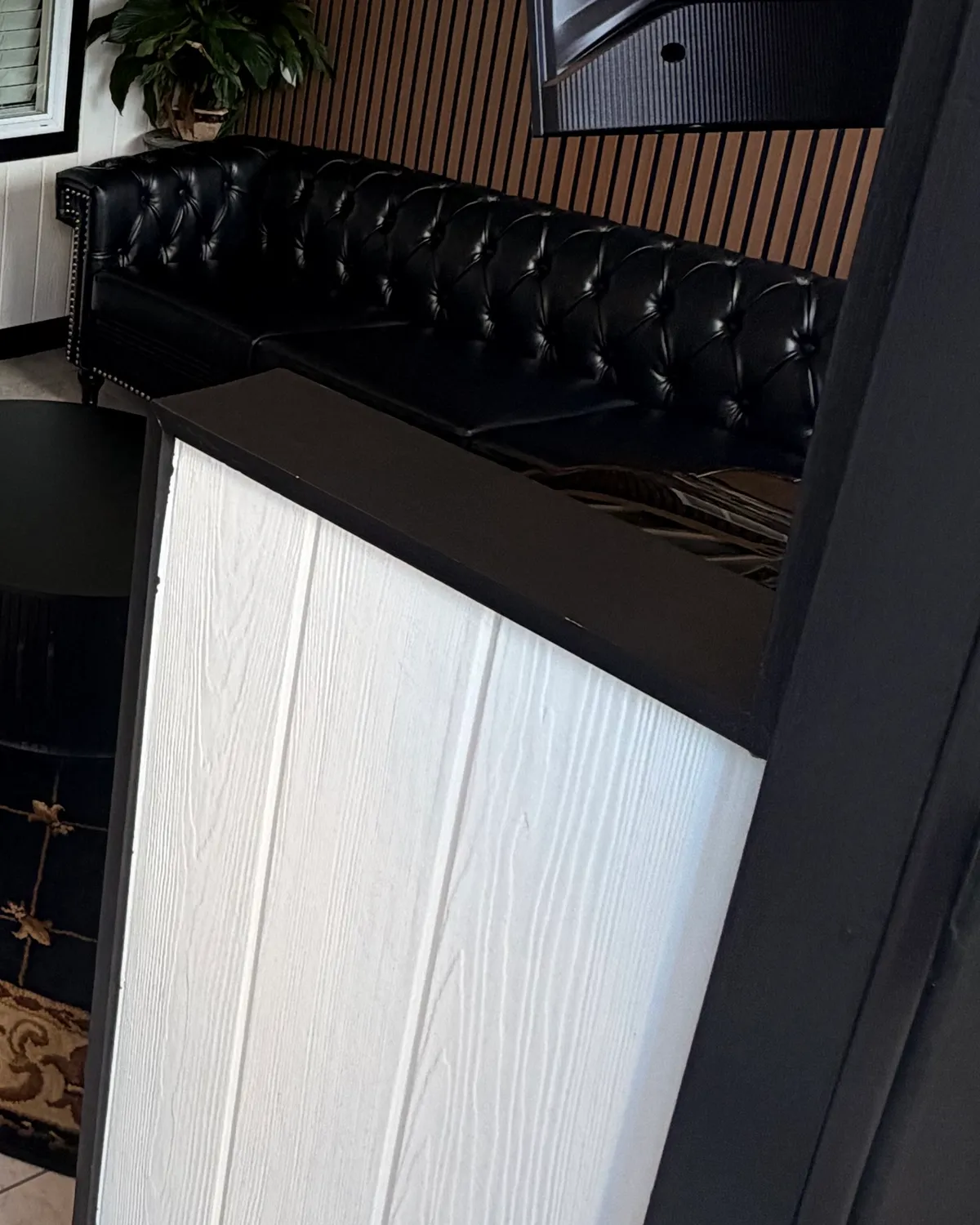 The customer waiting room at the Fleet Herald install studio, 3920 12th St NW, Canton, OH 44708: a tufted leather sofa against a slatted wood wall.